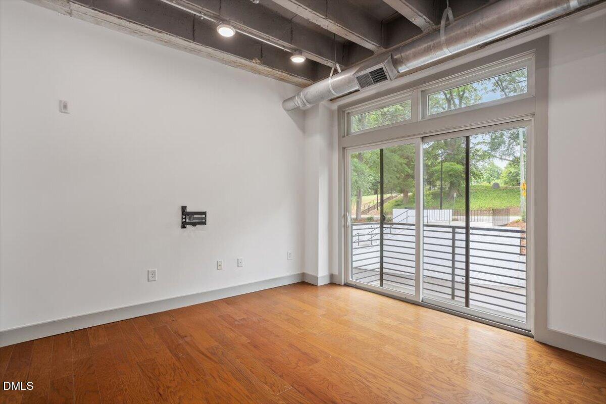 1300 St Marys Street, Unit 207 Raleigh, NC 27605 - Photo 7 of 31 a view of empty room with wooden floor and fan
