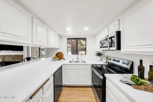 a kitchen with stainless steel appliances a sink a stove and cabinets