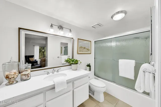 a bathroom with a sink mirror vanity and toilet