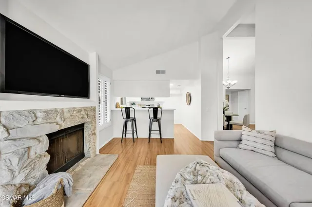 a living room with furniture a fireplace and a flat screen tv