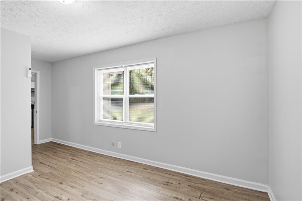 741 Roscoe Davis Road Monroe, GA 30656 - Photo 12 of 28 an empty room with wooden floor and windows