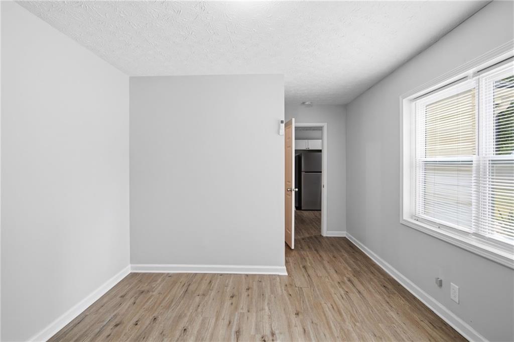741 Roscoe Davis Road Monroe, GA 30656 - Photo 13 of 28 an empty room with wooden floor and windows