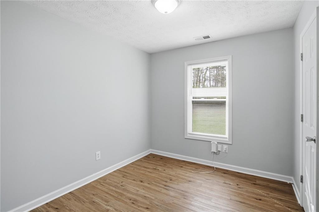 741 Roscoe Davis Road Monroe, GA 30656 - Photo 14 of 28 wooden floor in an empty room with a window