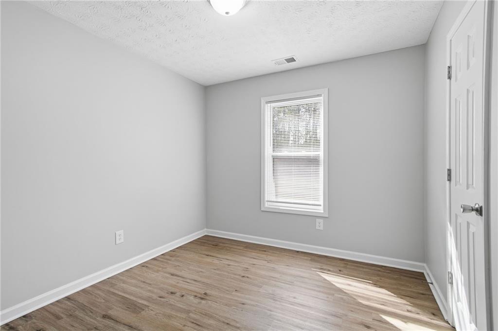 741 Roscoe Davis Road Monroe, GA 30656 - Photo 16 of 28 an empty room with wooden floor and windows