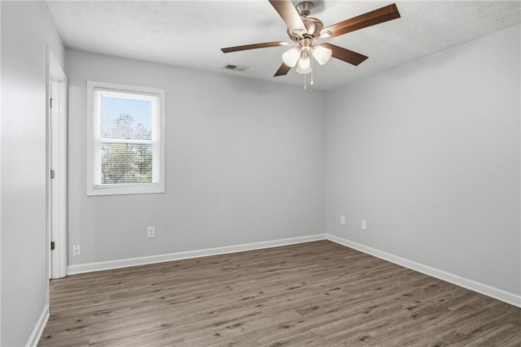 741 Roscoe Davis Road Monroe, GA 30656 - Photo 18 of 28 wooden floor in an empty room with a window