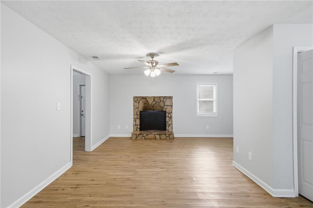 741 Roscoe Davis Road Monroe, GA 30656 - Photo 5 of 28 a view of an empty room with wooden floor and a ceiling fan