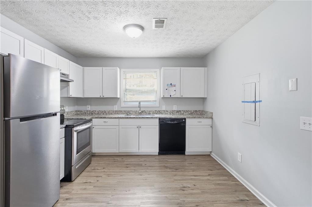 741 Roscoe Davis Road Monroe, GA 30656 - Photo 7 of 28 a kitchen with a refrigerator sink and stove