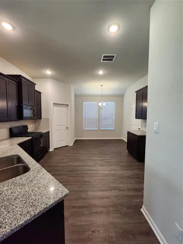 an empty room with wooden floor fireplace and windows