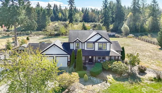 a aerial view of a house with a yard and large trees