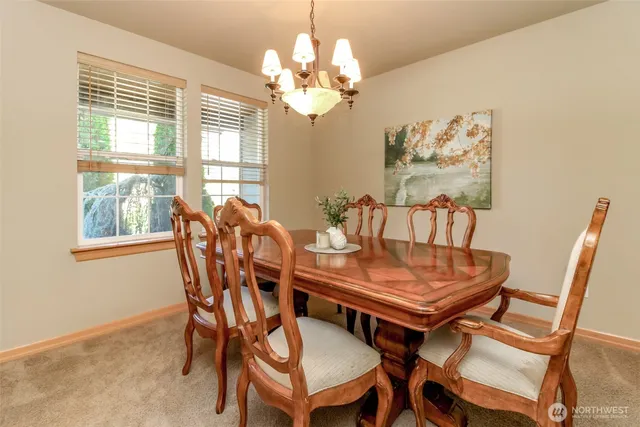 a view of a dining room with furniture and a chandelier
