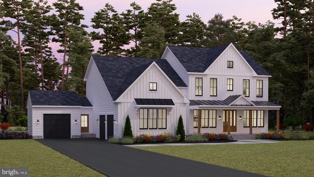 a front view of a house with a garden and trees