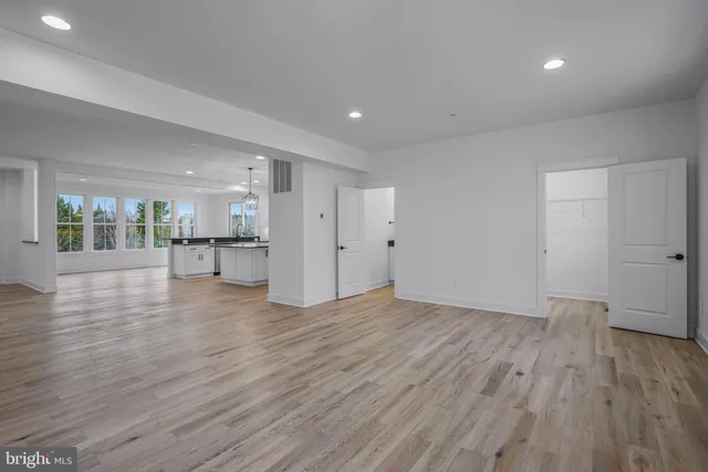 a view of empty room with wooden floor and a window