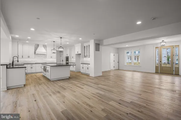 a large kitchen with stainless steel appliances kitchen island a large counter top a stove and a refrigerator