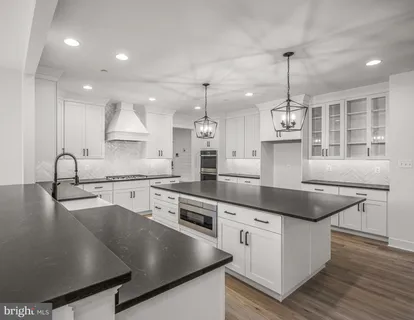 a kitchen with stainless steel appliances granite countertop a sink a stove and a wooden floors