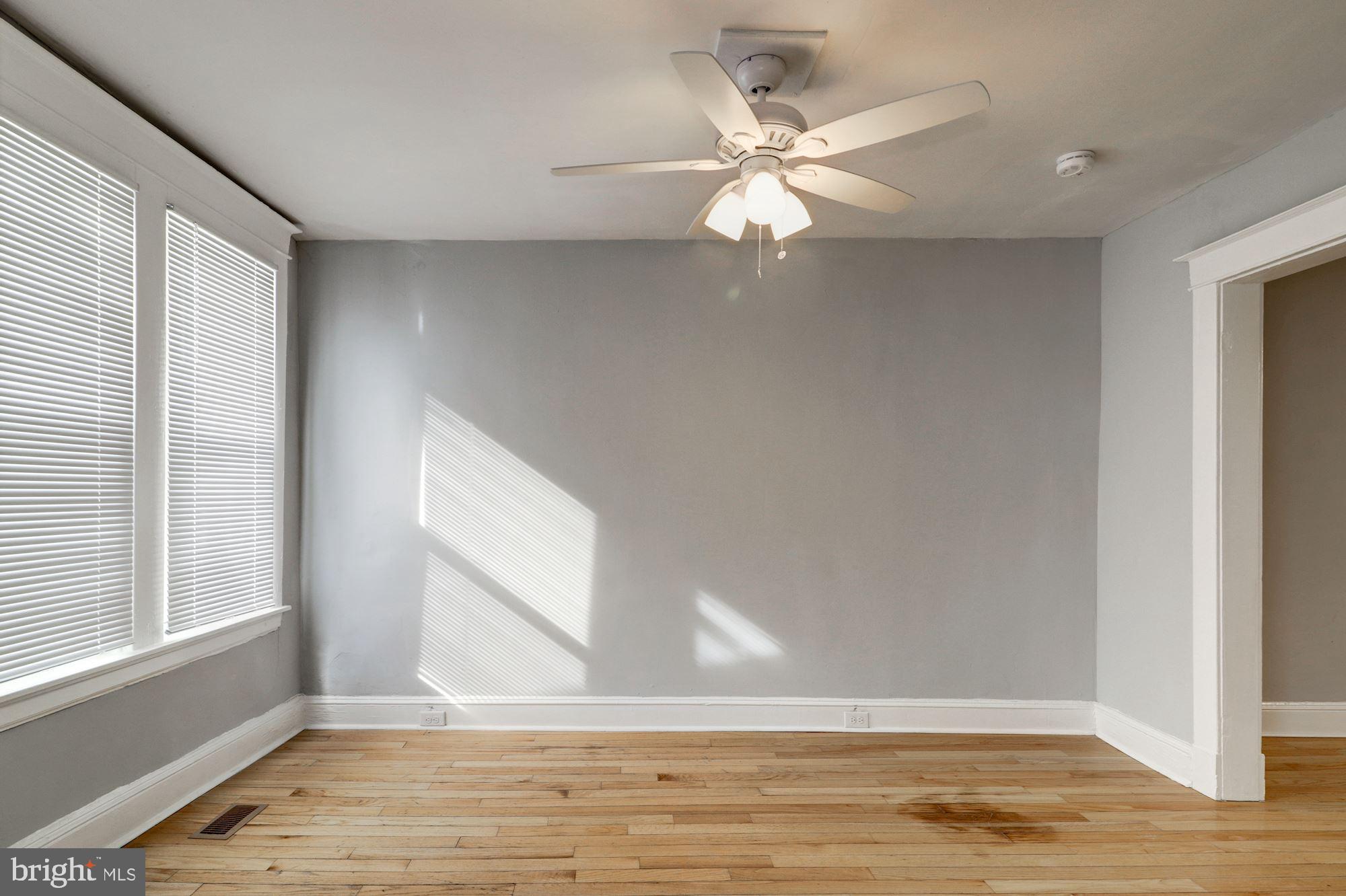 1016 North Rosedale Street Baltimore, MD 21216 - Photo 14 of 58 a view of an empty room with wooden floor and fan