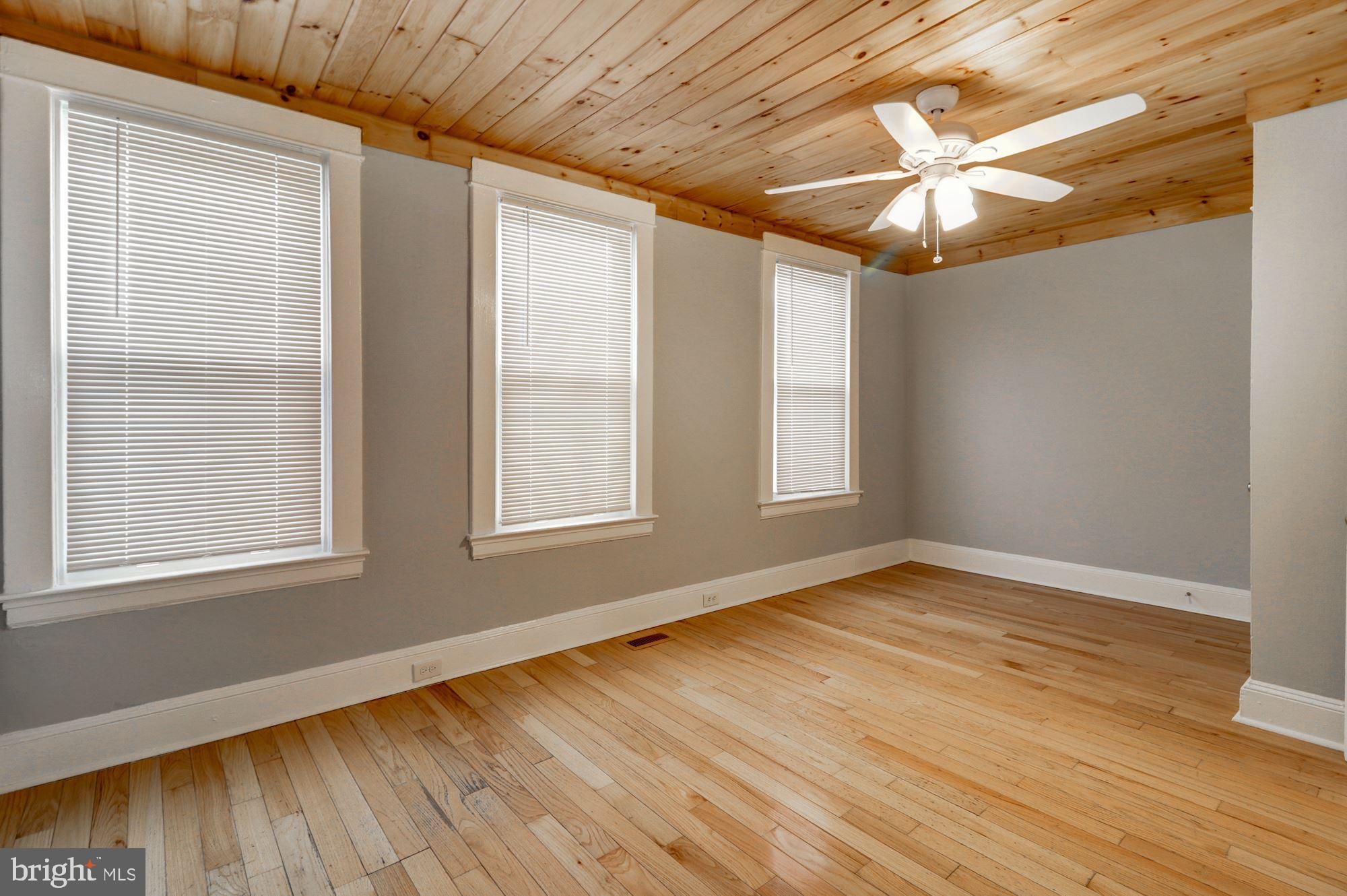 1016 North Rosedale Street Baltimore, MD 21216 - Photo 37 of 58 an empty room with wooden floor fan and windows