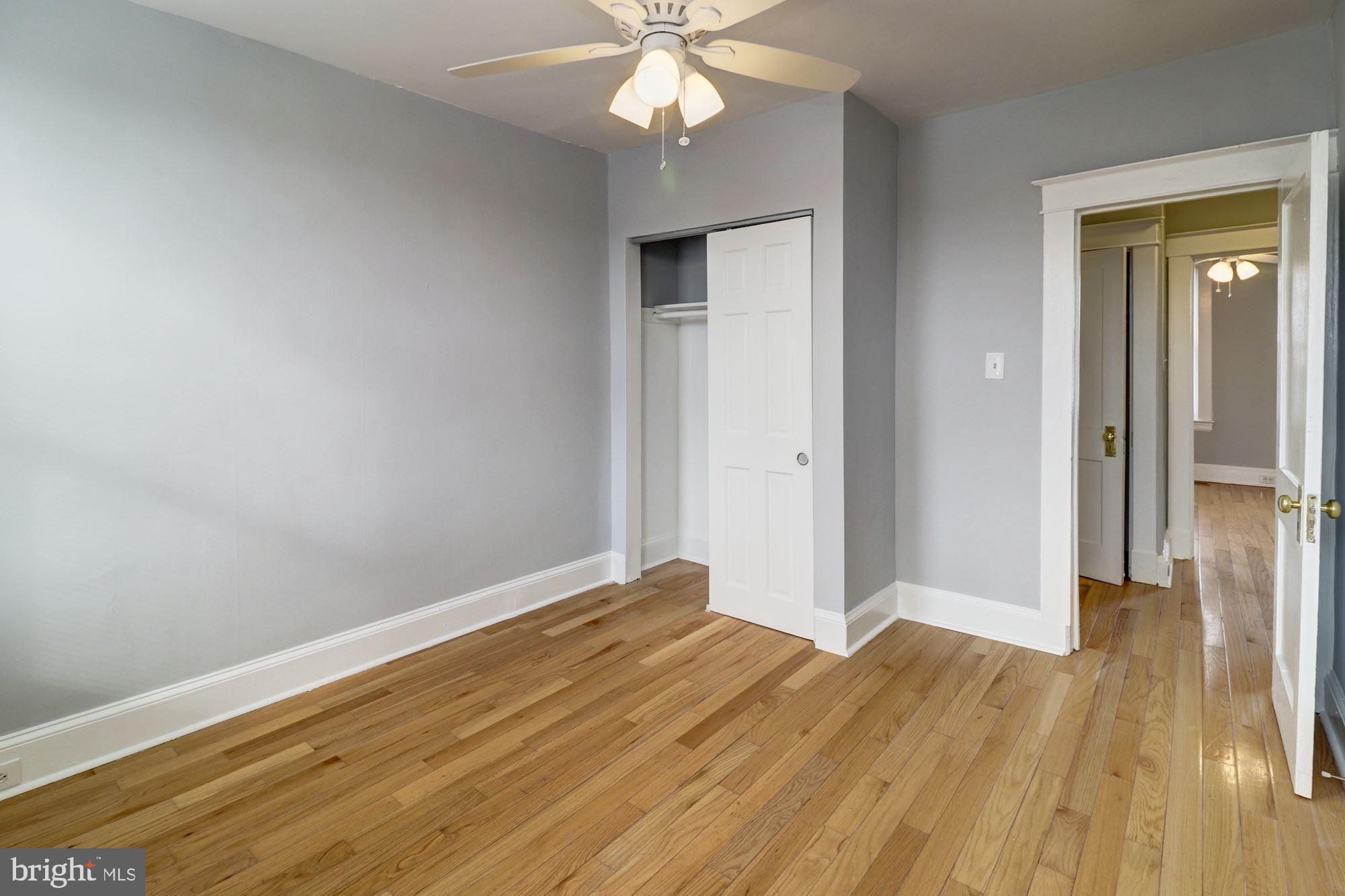 1016 North Rosedale Street Baltimore, MD 21216 - Photo 42 of 58 a view of a room with wooden floor and a ceiling fan