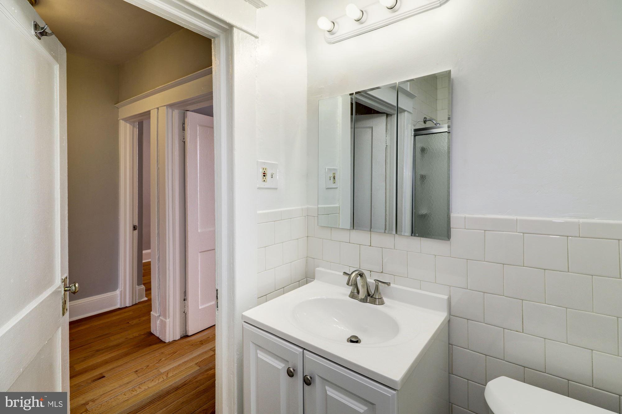 1016 North Rosedale Street Baltimore, MD 21216 - Photo 44 of 58 a bathroom with a sink toilet and mirror