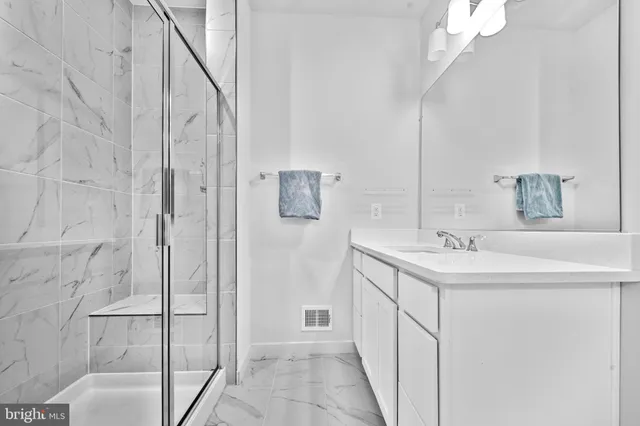 a bathroom with a shower sink and mirror