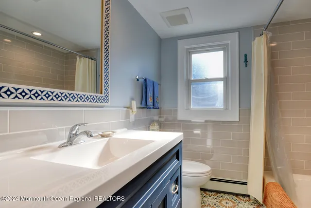 a bathroom with a sink toilet and mirror