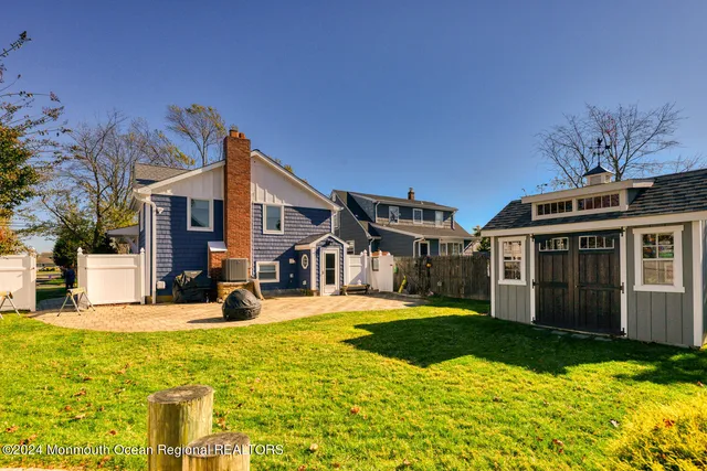 a view of a house with a big yard and large trees