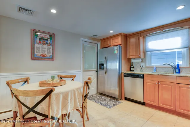 a kitchen with stainless steel appliances kitchen island granite countertop a table and chairs in it