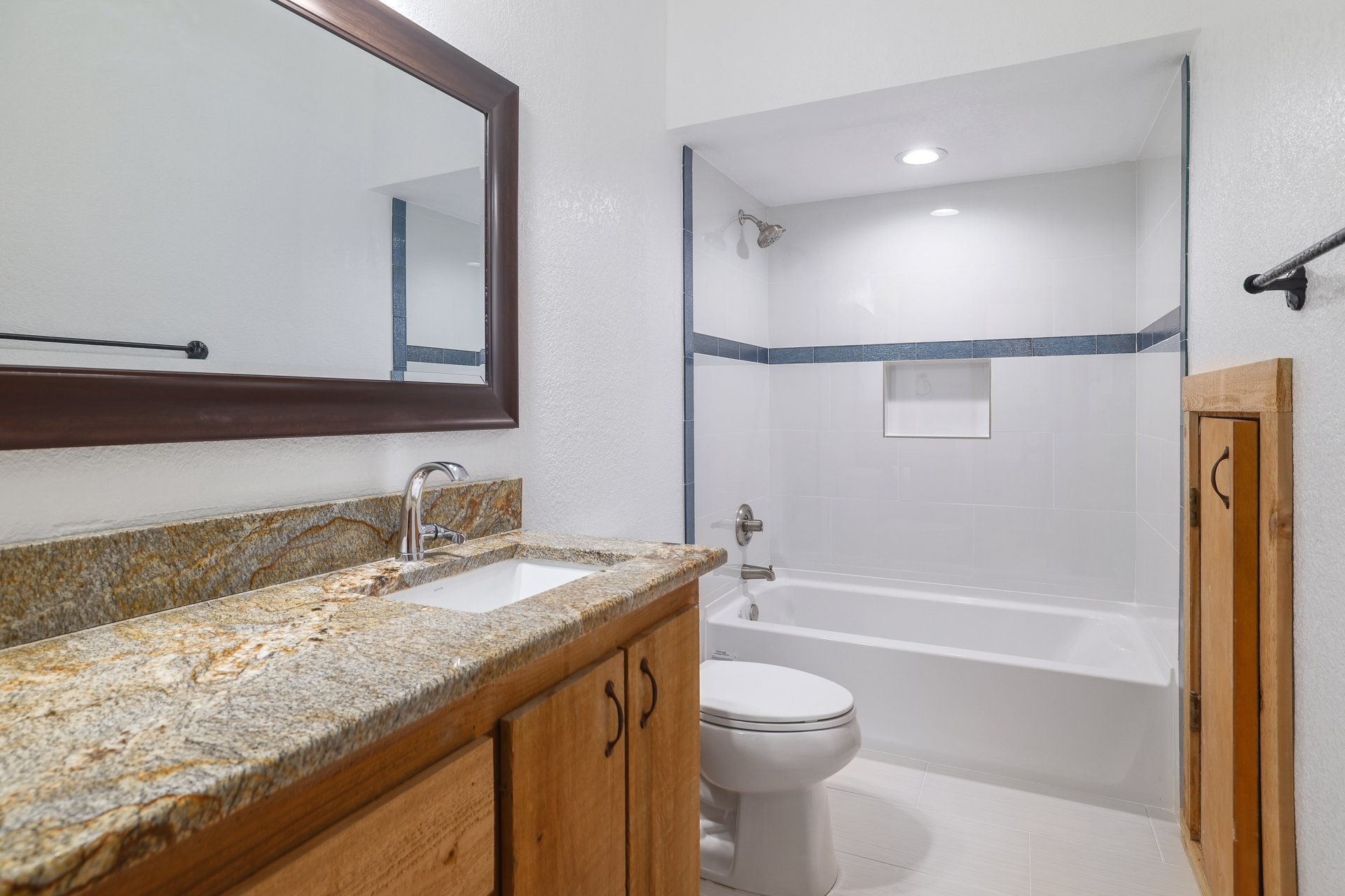 313 Kendall Road Spicewood, TX 78669 - Photo 20 of 34 Bathroom featuring shower / bathtub combination, vanity, light tile patterned flooring, and a textured wall