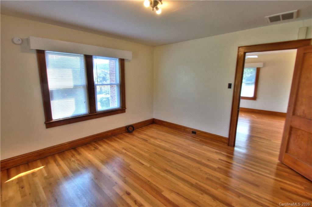 451 Possum Ridge Road Canton, NC 28716 - Photo 14 of 44 a view of an empty room with wooden floor and a window