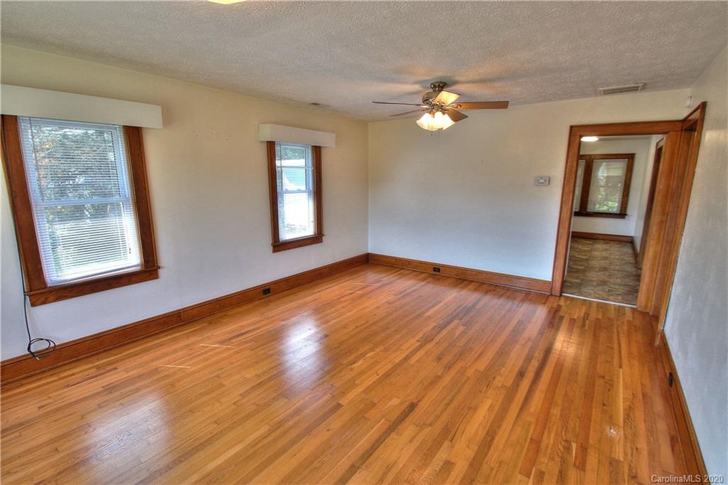 451 Possum Ridge Road Canton, NC 28716 - Photo 40 of 44 a view of empty room with wooden floor and fan
