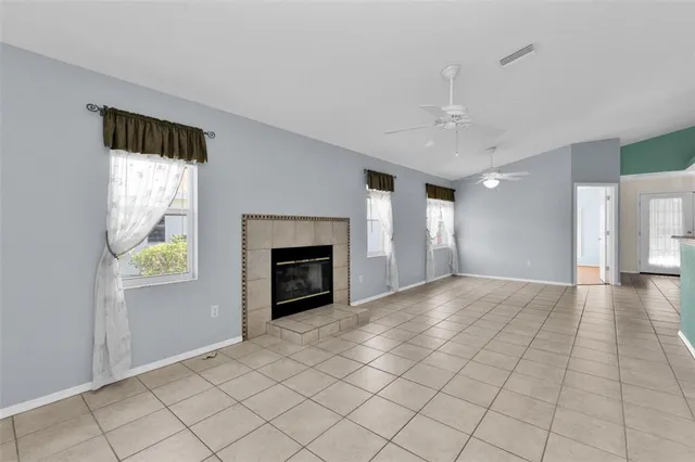 a view of an empty room with a fireplace and a window