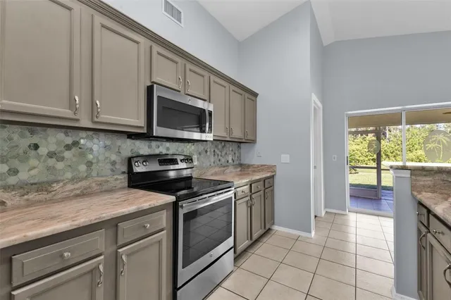 a kitchen with stainless steel appliances granite countertop a stove a sink and a microwave