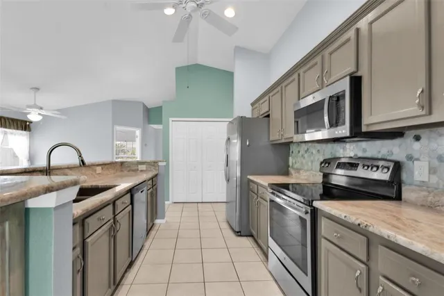 a kitchen with stainless steel appliances granite countertop a sink and a microwave