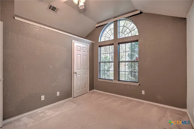 an empty room with windows and closet