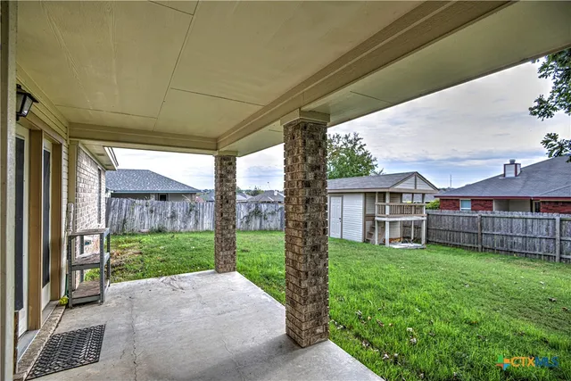 a view of a house with a big yard and large trees