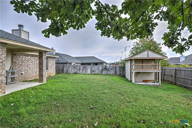 a view of a house with a yard and sitting area