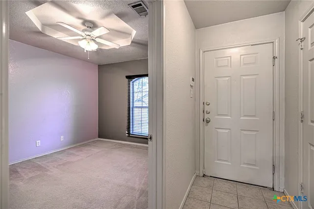 en empty room with windows and fan