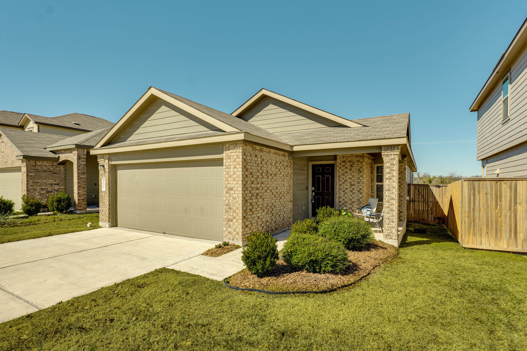 557 Greatest Gift Way Jarrell, TX 76537 - Photo 1 of 39 Ranch-style home with brick siding, a front lawn, driveway, and a garage