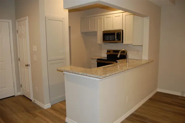 a view of kitchen with wooden floor and electronic appliances