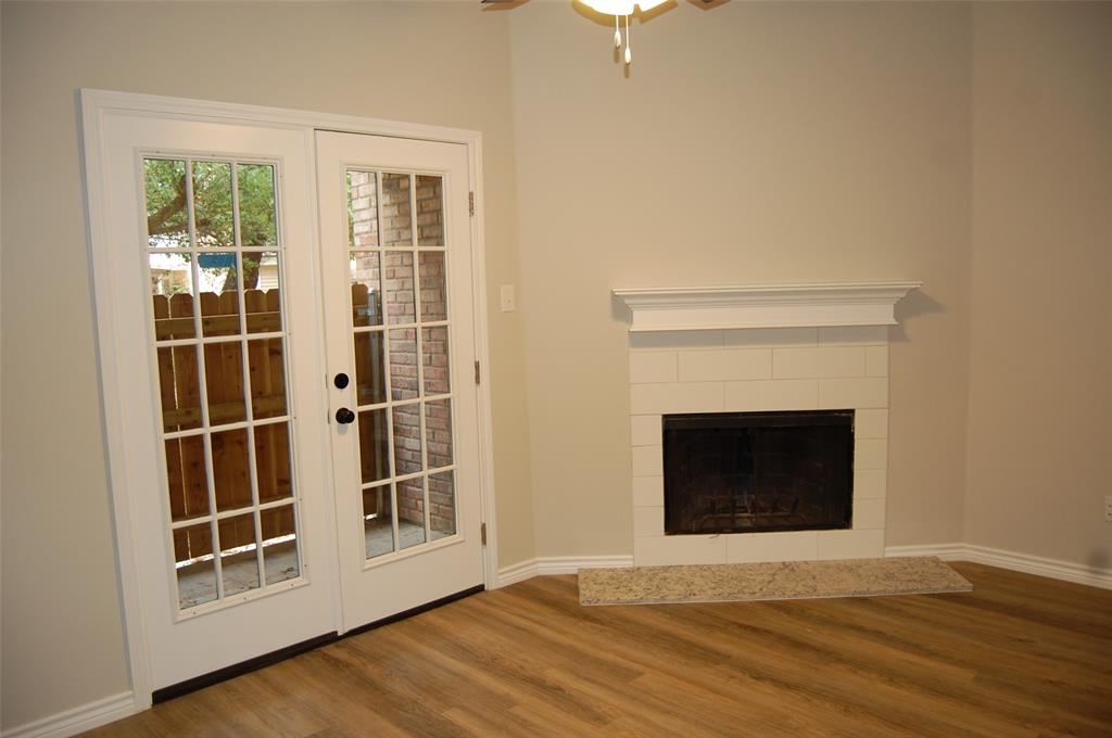 5325 Bent Tree Forest Drive, Unit 1102 Dallas, TX 75248 - Photo 14 of 28 an empty room with wooden floor a fireplace and windows