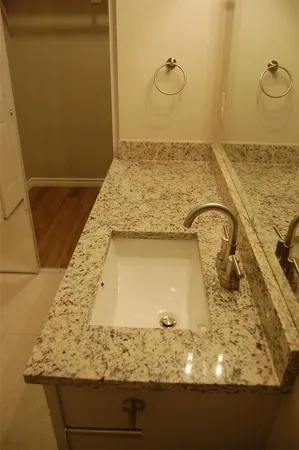 a bathroom with a granite countertop sink