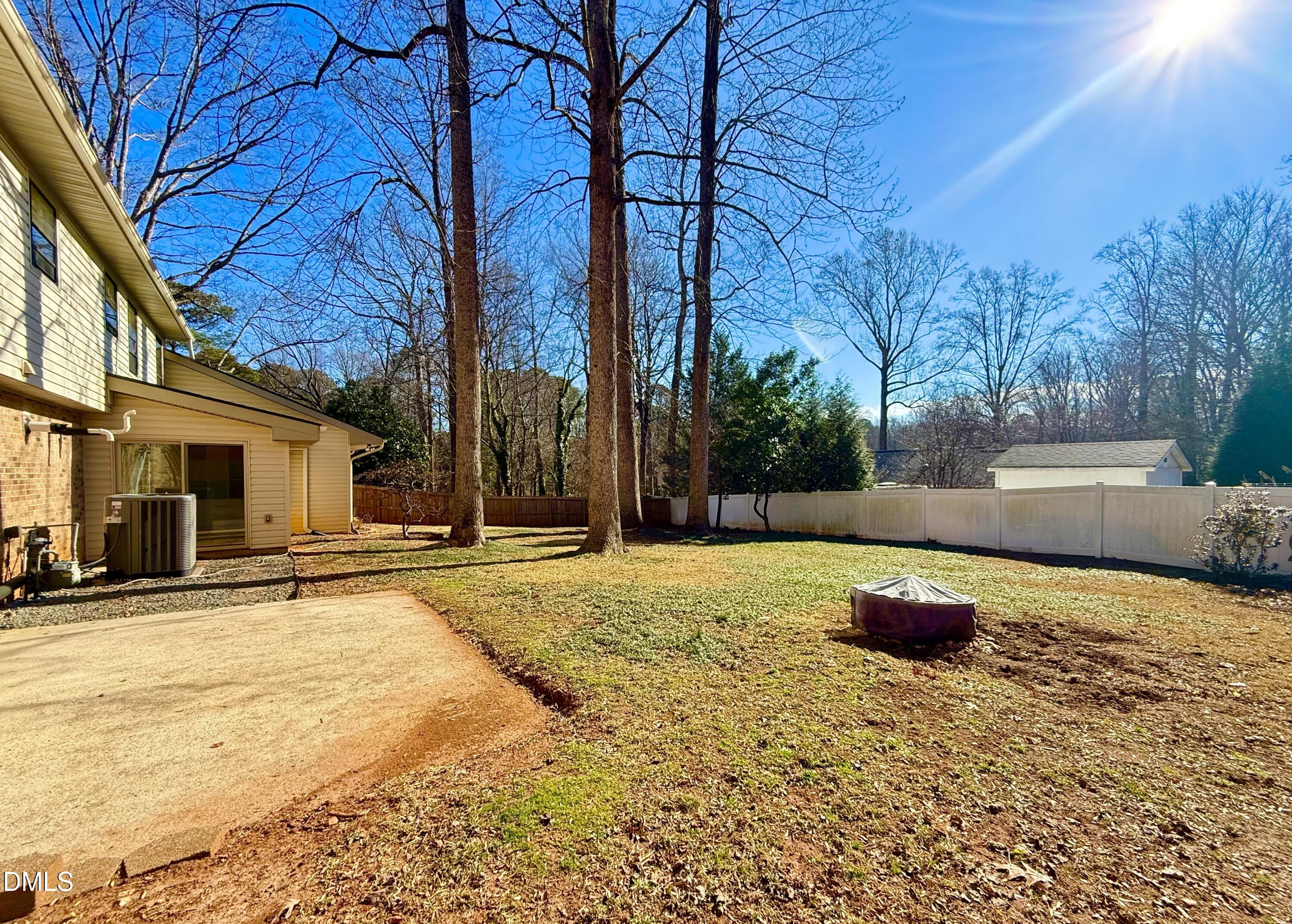 702 Delmar Road Cary, NC 27511 - Photo 4 of 23 a backyard of a house with table and chairs under an umbrella
