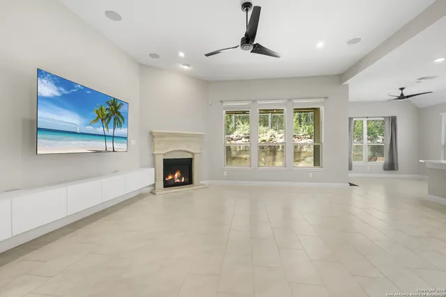 a view of an empty room with a fireplace and a window