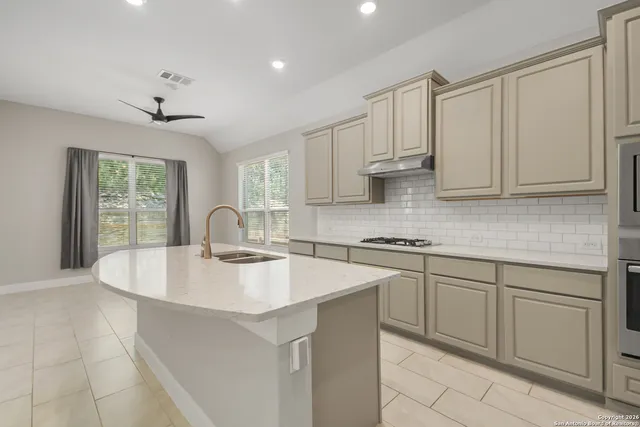 a kitchen with stainless steel appliances granite countertop a sink stove and cabinets