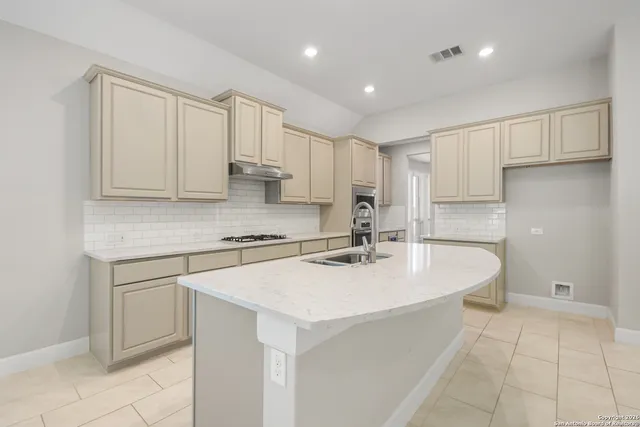 a large kitchen with stainless steel appliances granite countertop a stove and a sink