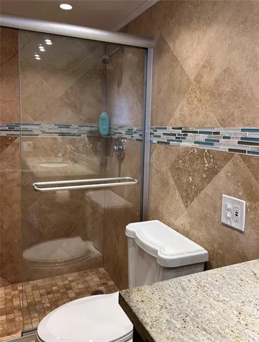 a bathroom with a toilet and a shower