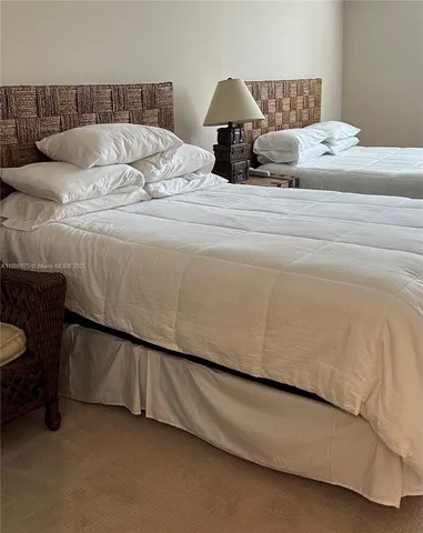 a large bed sitting in a bedroom next to a lamp