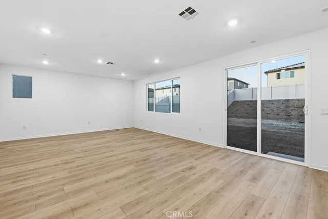 a view of a big room with wooden floor and windows