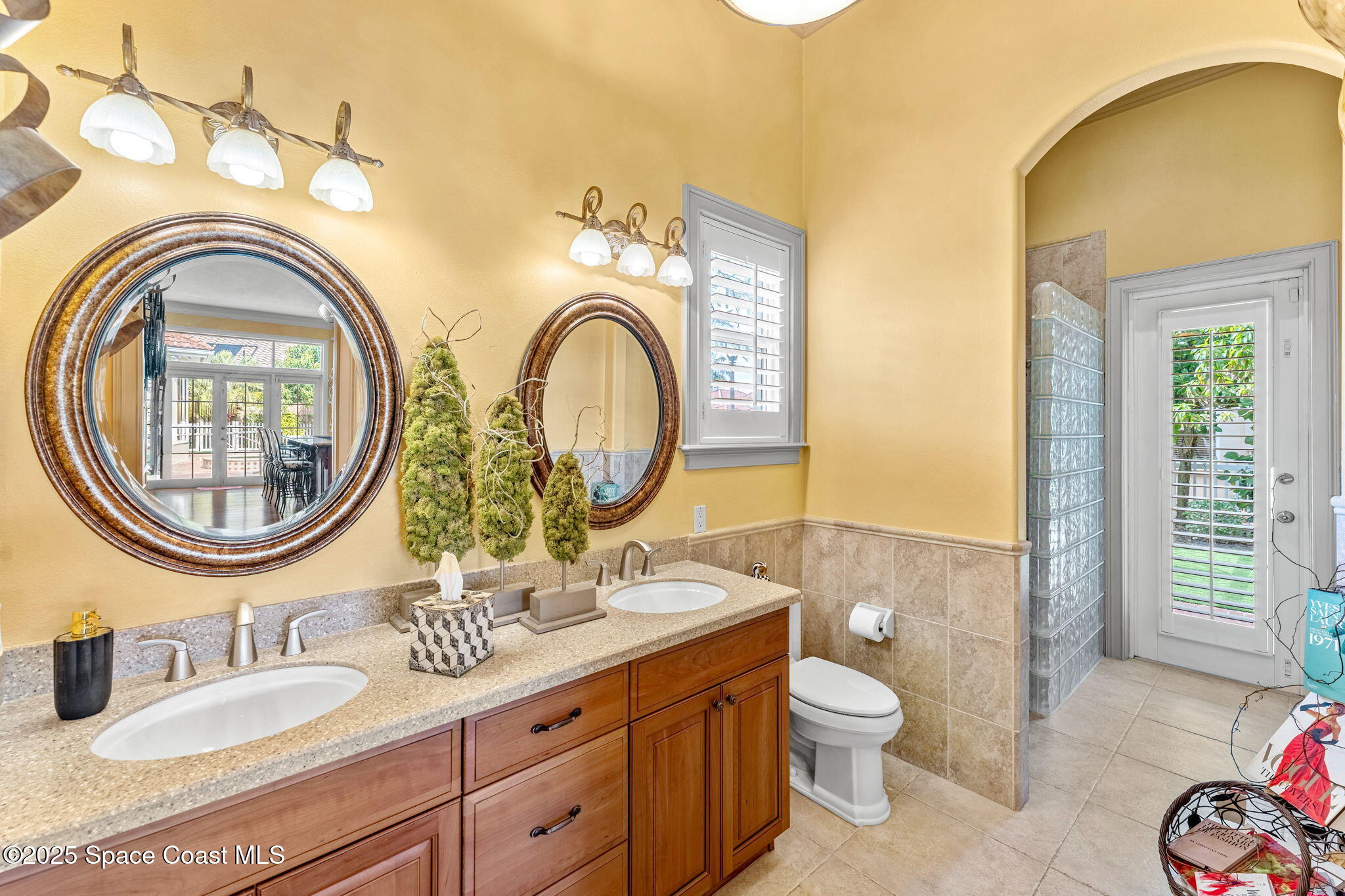 3738 Cappio Drive Melbourne, FL 32940 - Photo 32 of 62 a bathroom with a granite countertop toilet a sink and a mirror