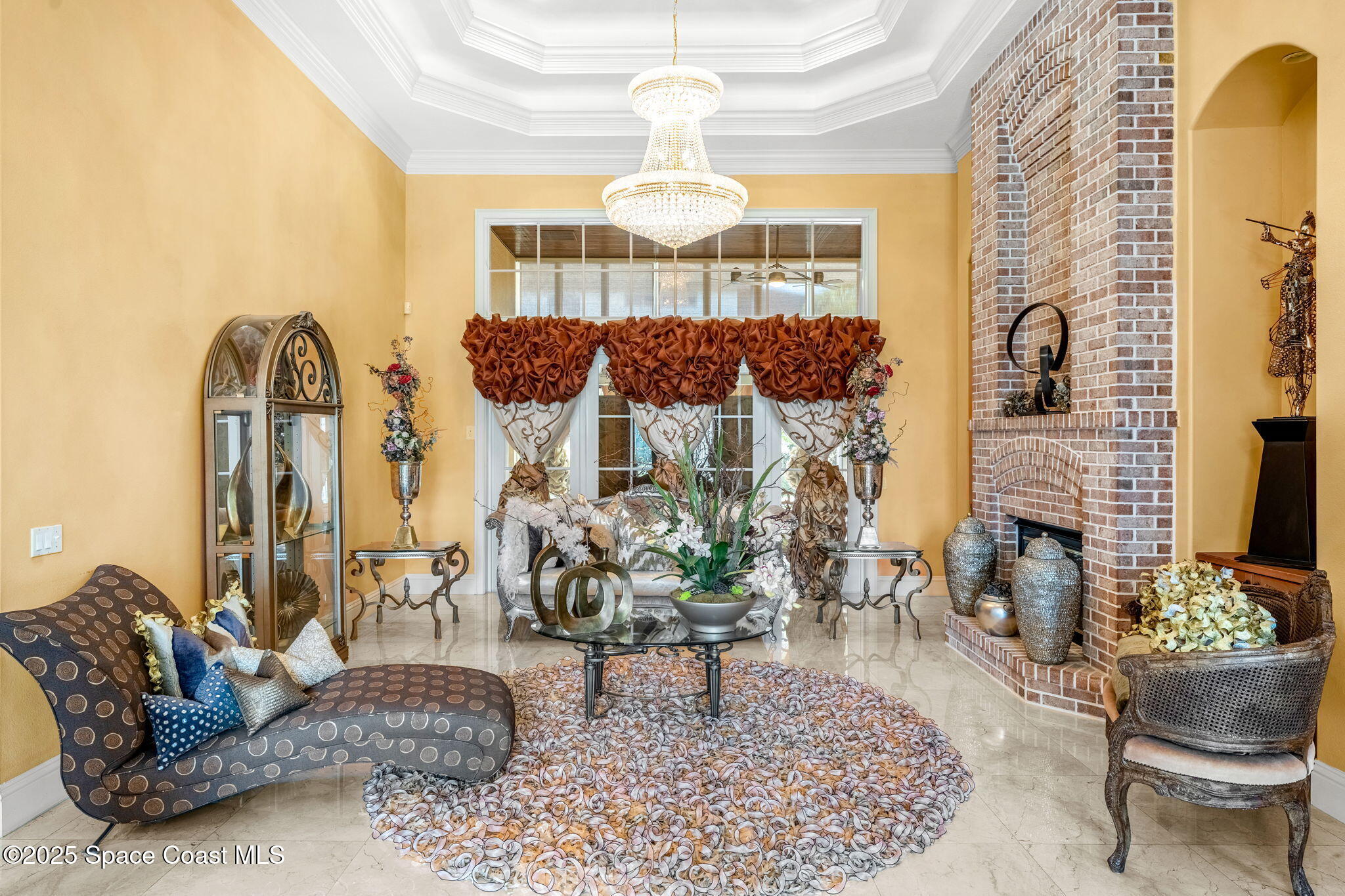 3738 Cappio Drive Melbourne, FL 32940 - Photo 5 of 62 a living room with furniture a fireplace and a chandelier