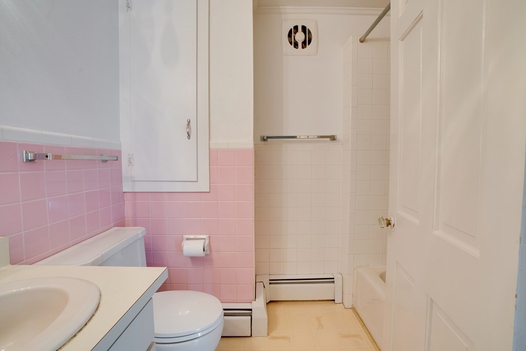 156 Chestnut Street, Unit 6 North Andover, MA 01845 - Photo 15 of 27 a white toilet sitting next to a bathroom sink and vanity